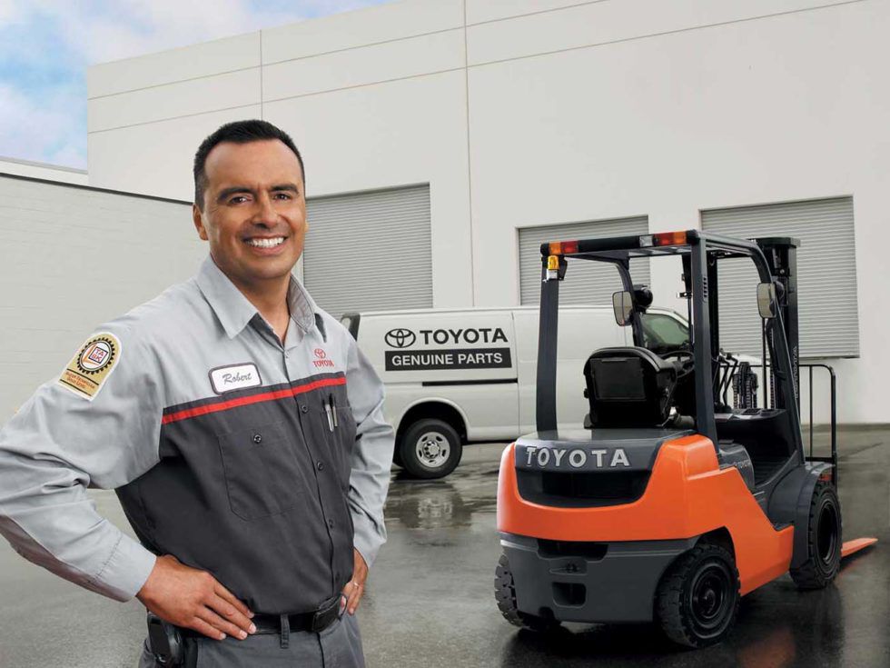 Toyota Service Technician standing next to Toyota Forklift