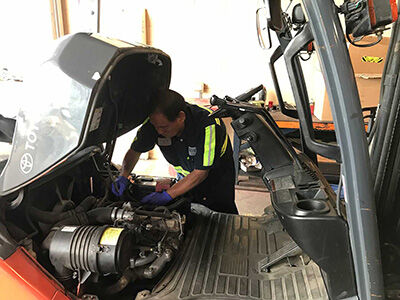 Service technician working on a forklift.